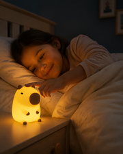 Child tapping CapiZen capybara night light beside the bed – image 2