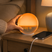 DawnRise sunrise alarm clock being set up beside a phone and USB cable – image 6