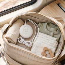 BabyCalm portable white noise machine packed in a changing bag with USB cable