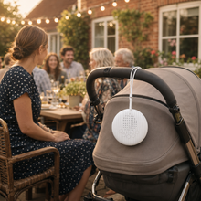BabyCalm portable white noise machine supporting a pram nap at a family garden gathering