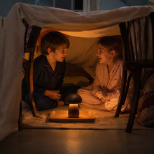Children enjoying the warm CapLume glow inside a cosy blanket fort