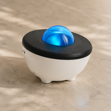 StarLens projector close-up showing the white base, black ridged top and blue dome
